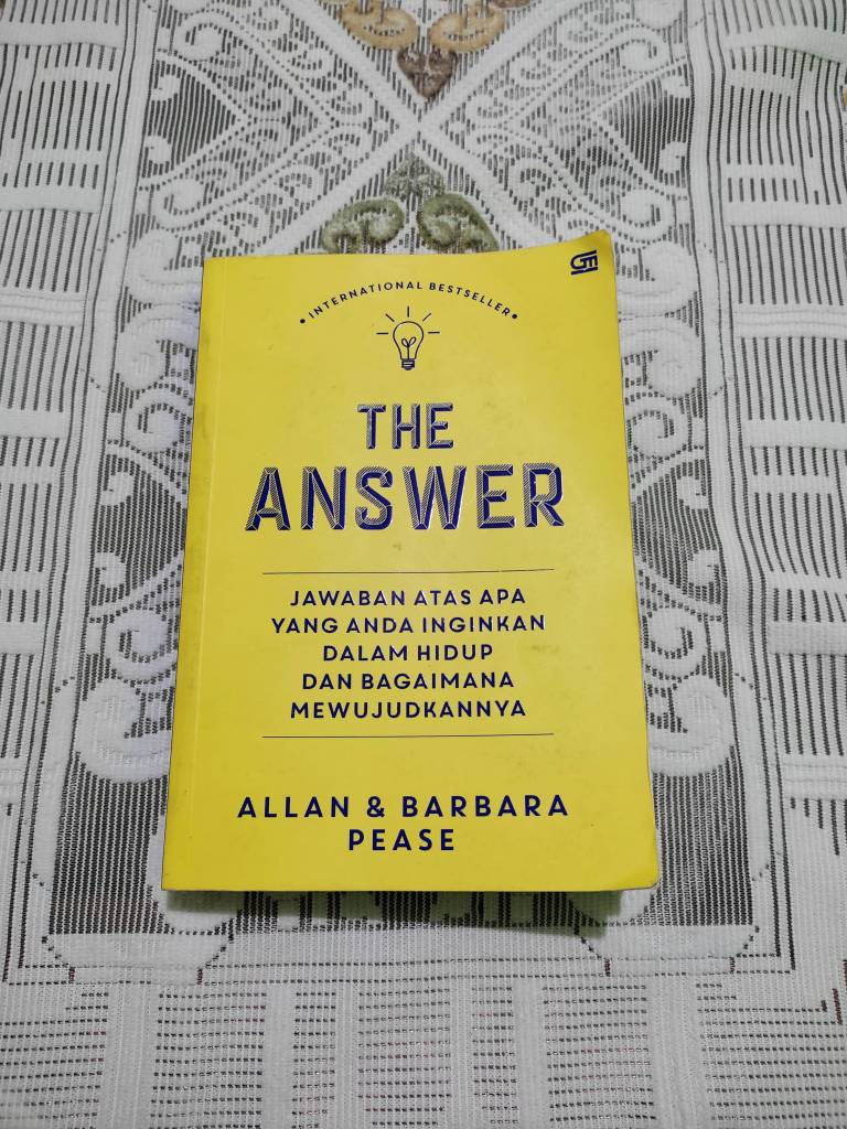 Cover of the book 'The Answer' by Allan & Barbara Pease, featuring a bright yellow background with blue text.
